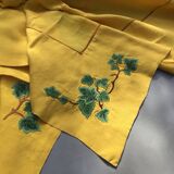 Yellow linen dinner service embroidered with ivy flowers