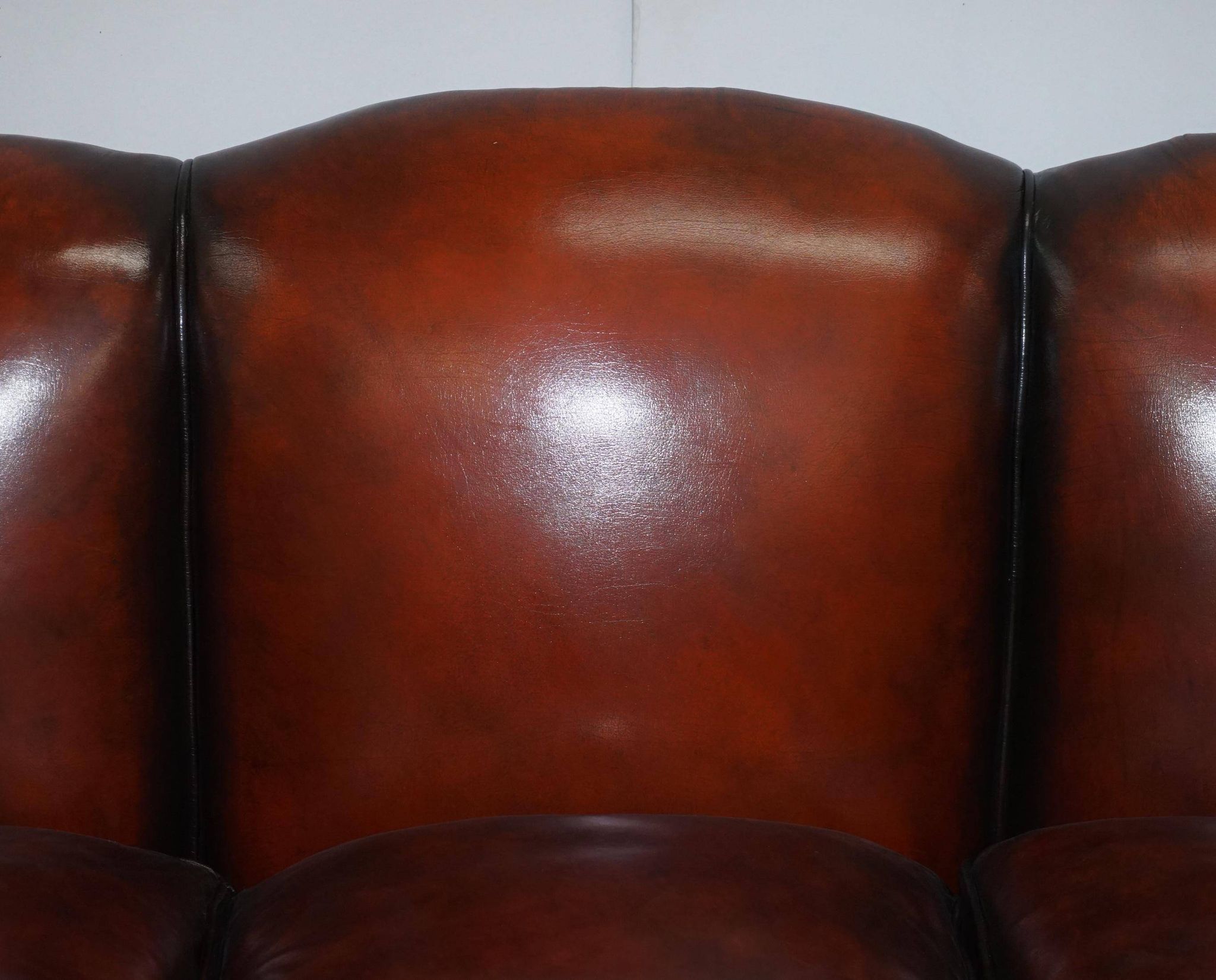 Restored Victorian sofa in leather with claw feet and feather cushions.