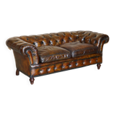 Victorian Chesterfield leather upholstered canapé with feather cushions.