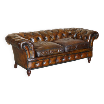 Victorian Chesterfield leather upholstered canapé with feather cushions.