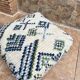 Berber floor pouf: Handwoven Moroccan wool cushion.