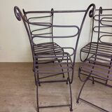 Series of four designer cast iron chairs with reversed backs and very beautiful x-legs