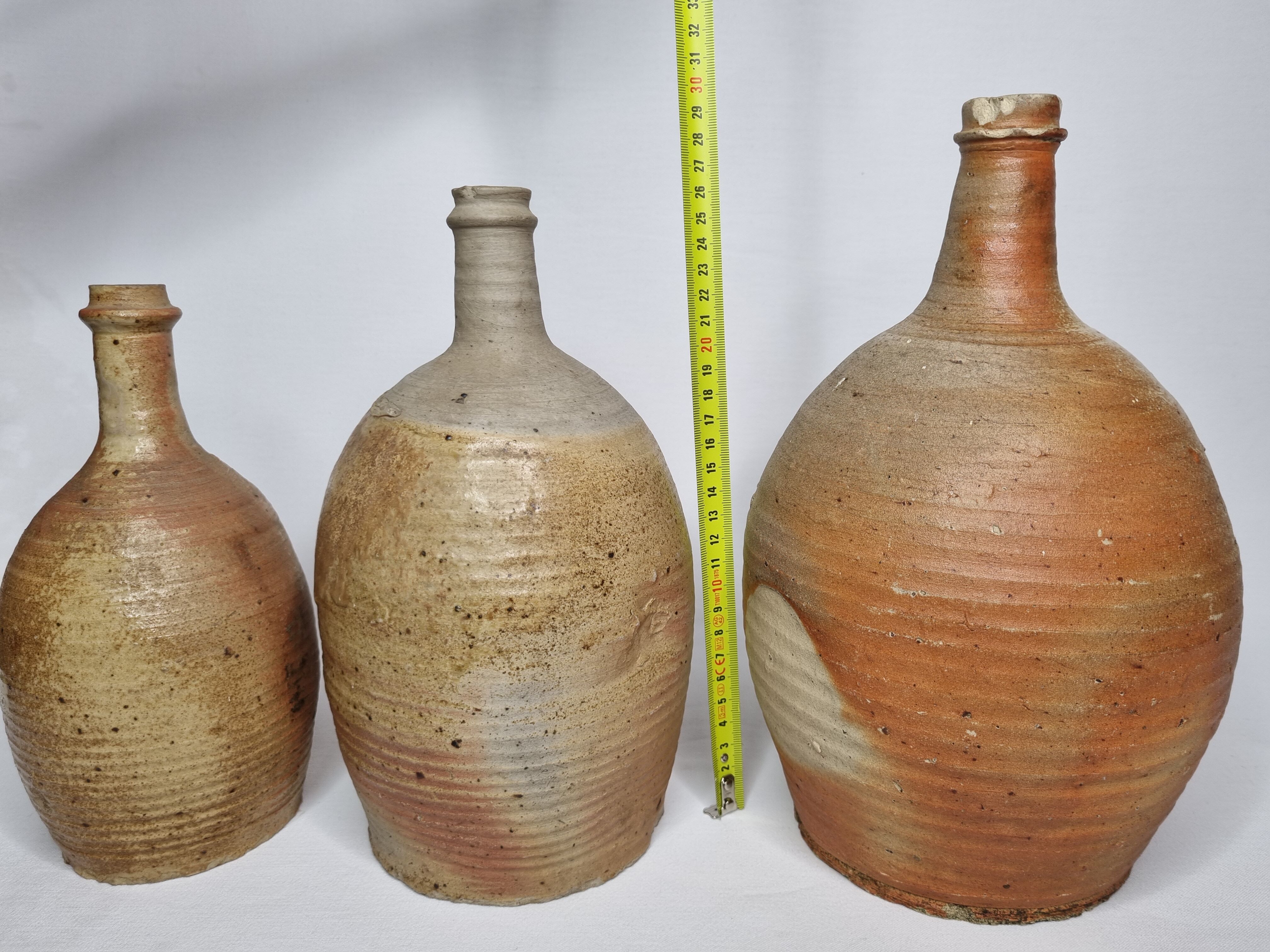 Set of three enamelled terracotta bottles