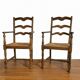Pair of rustic antique armchairs in wood and woven straw.