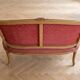 Two-seater Louis XV style sofa in red fabric.
