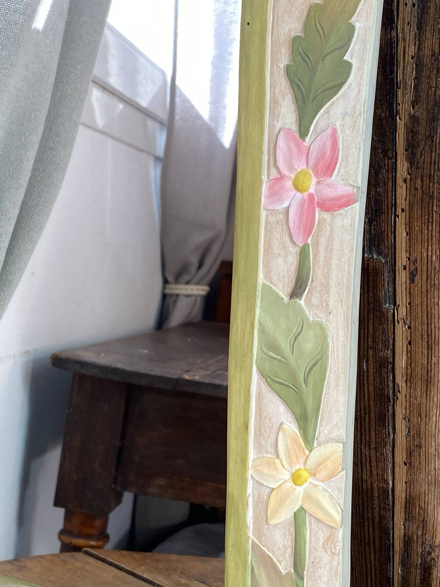 Carved wooden mirror, colourful floral decoration.