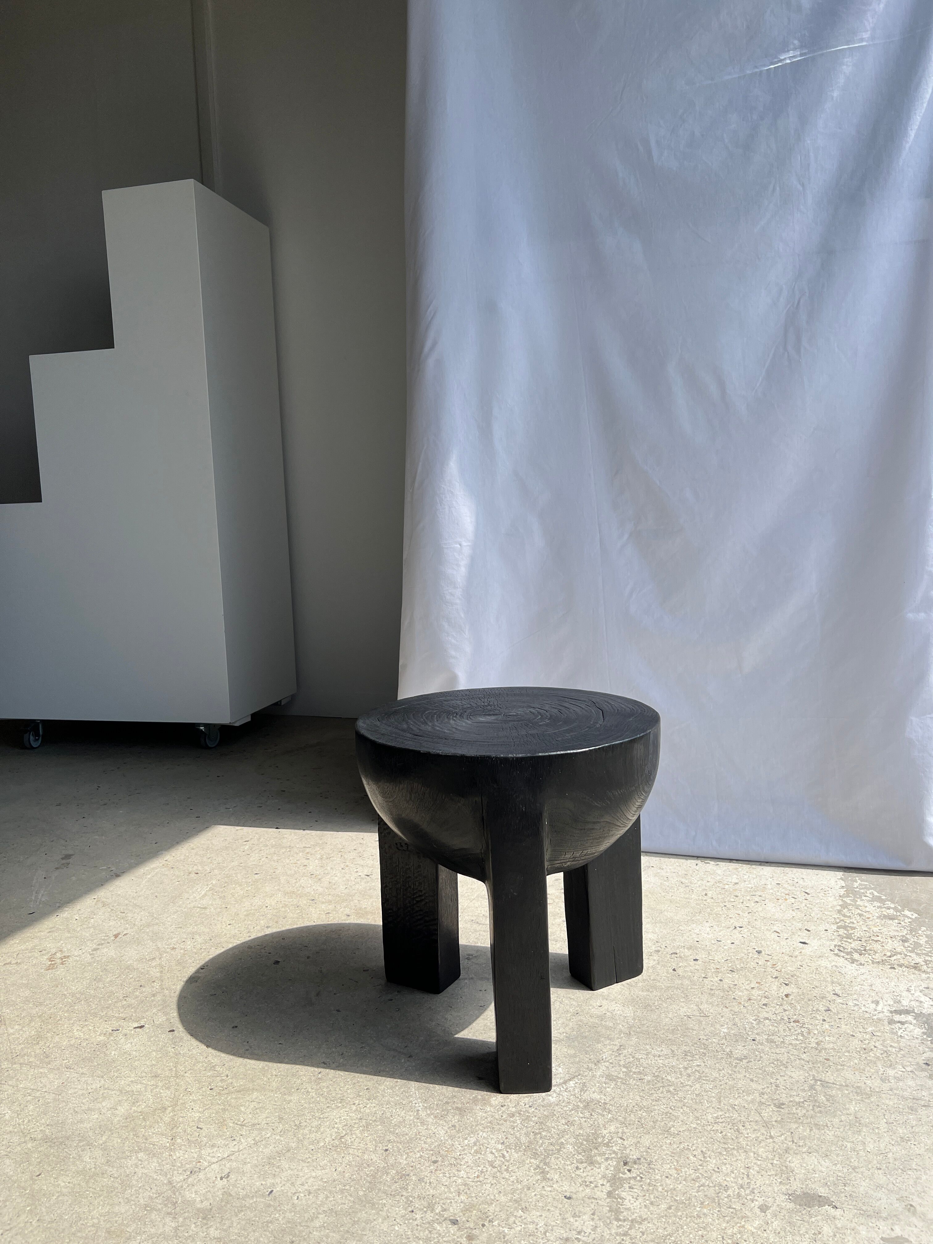 Black mango wood tripod side table with a semi-spherical top, height: 45 cm, diameter: 44 cm.