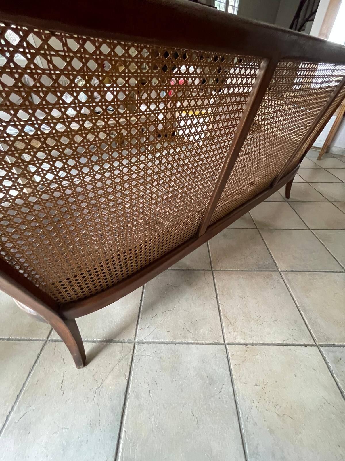 Sofa with backrest and cane armrests