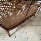 Sofa with backrest and cane armrests