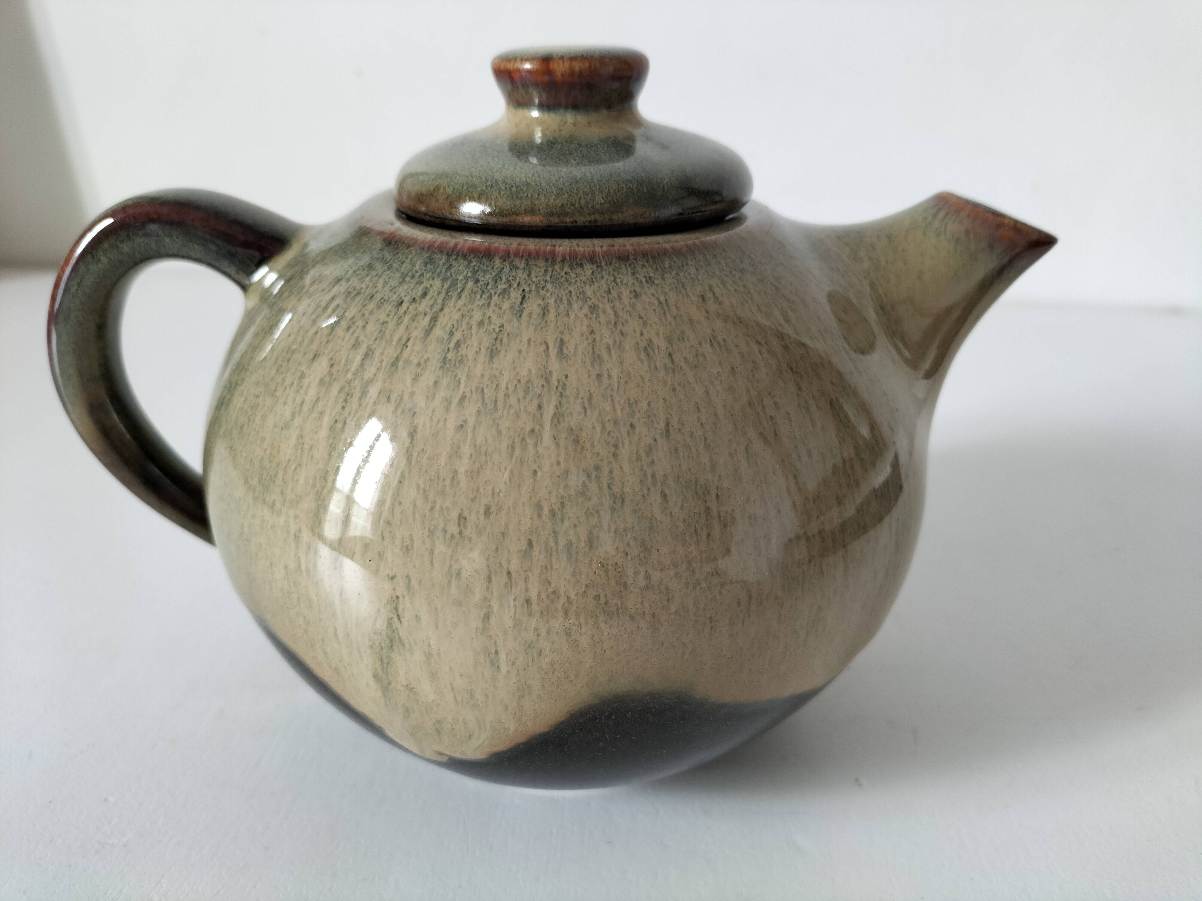 Vintage ceramic teapot with a flame design.