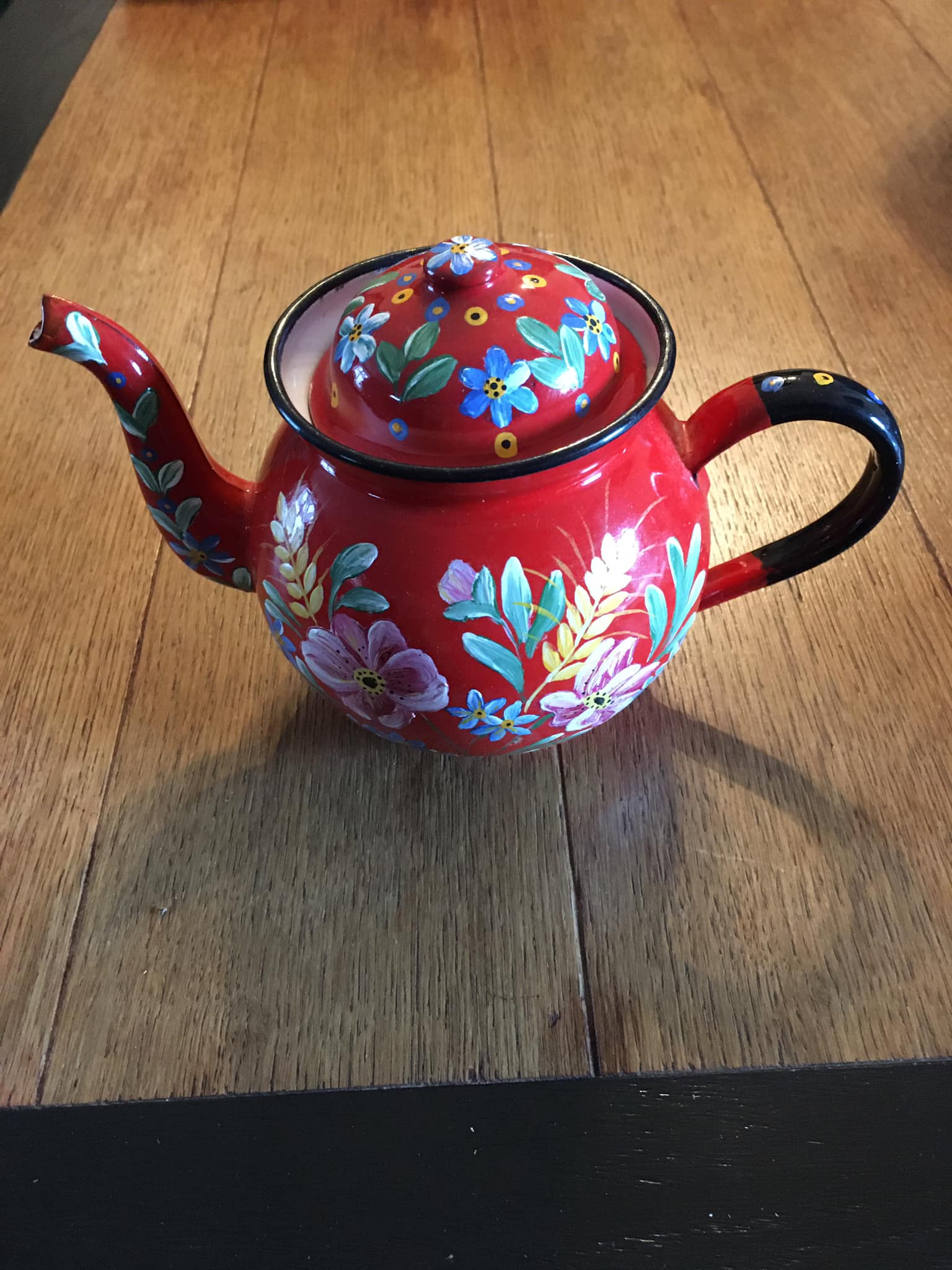 Red enamel teapot with hand-painted floral decoration