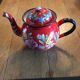 Red enamel teapot with hand-painted floral decoration
