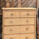 Large antique English chest of drawers in raw solid wood.