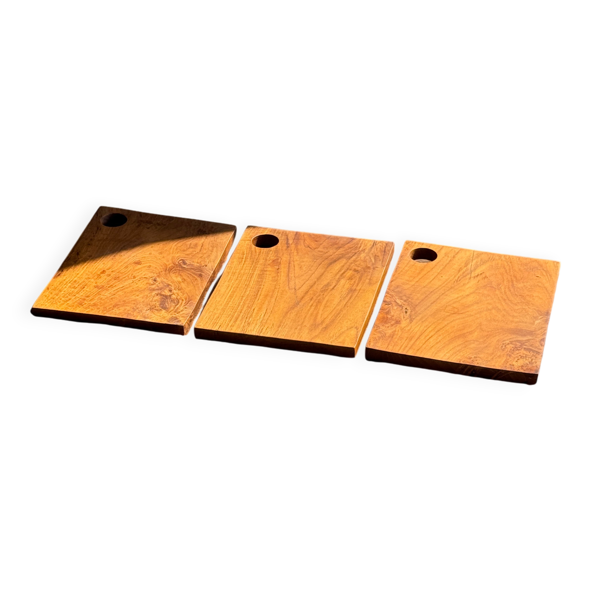 Small rectangular teak monoxyle cutting board with a circular handle.