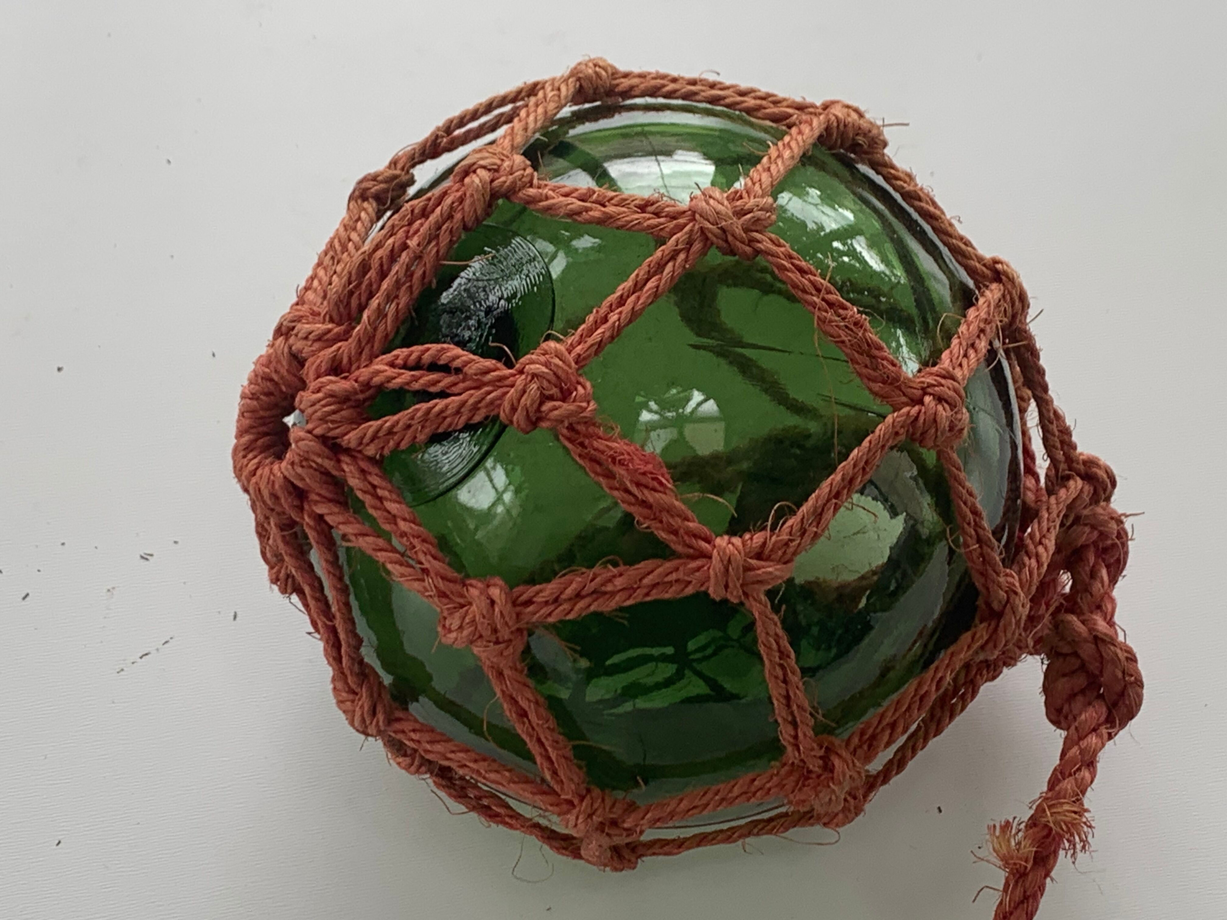 Globe, green glass float and vintage rope