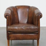 Fauteuil club en cuir de mouton foncé avec passepoil noir
