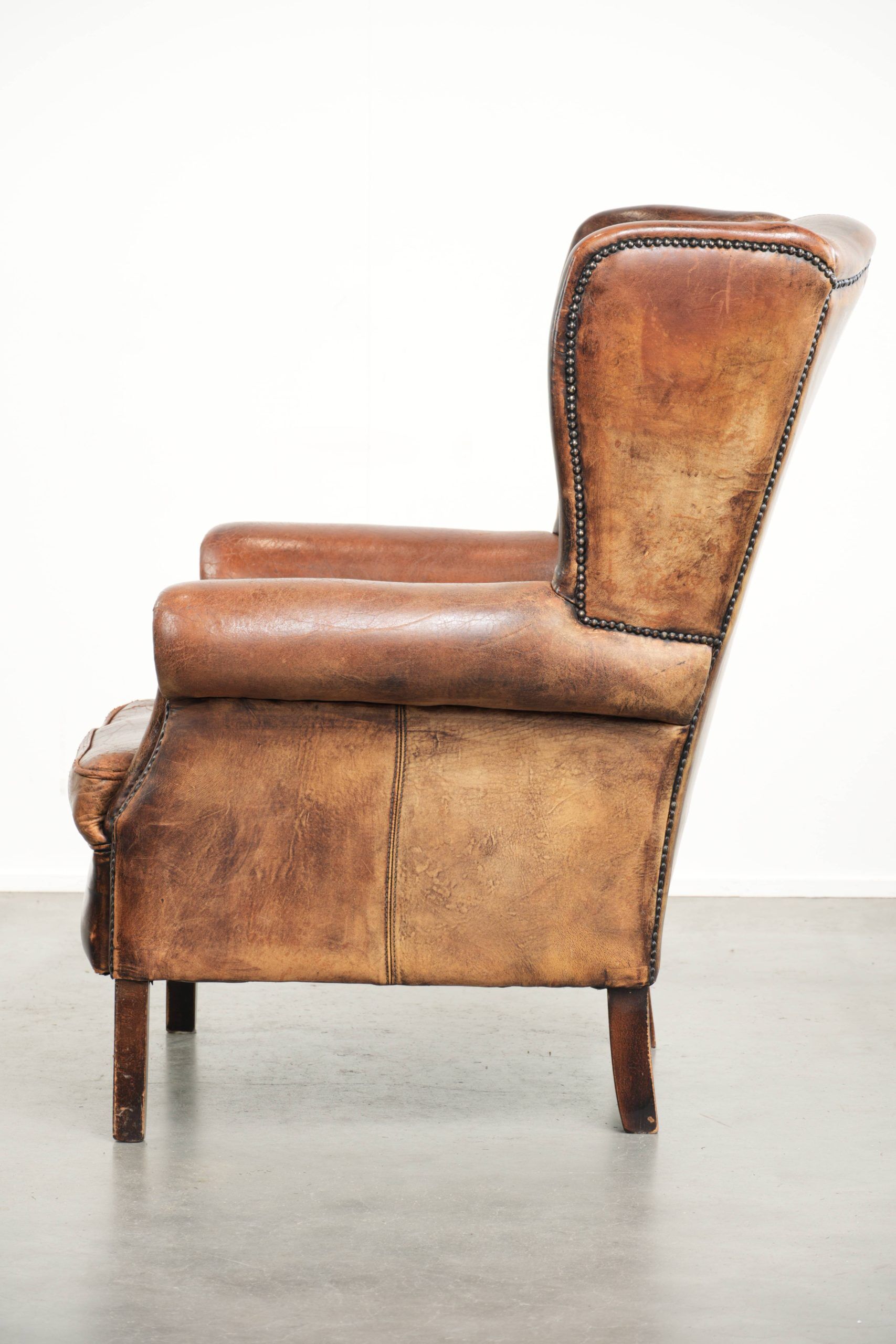 Vintage sheepskin wingback armchair in a deep brown colour finished