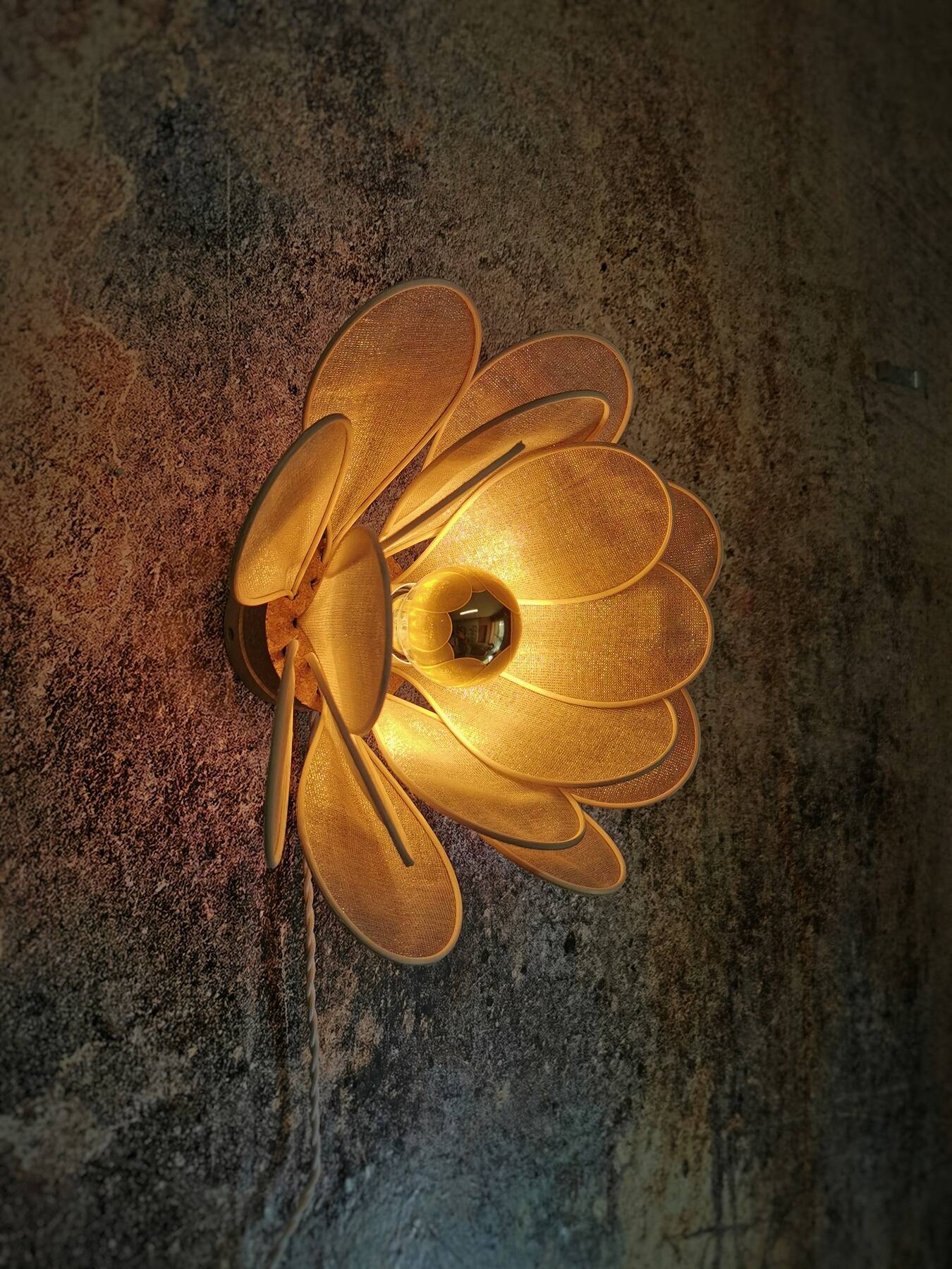 Flower wall light made of rattan petals and gold fabric