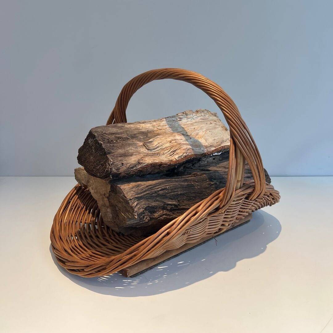 Woven Rattan Log Holder in a Semi-Round Shape with a Central Arched Handle.