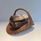 Woven Rattan Log Holder in a Semi-Round Shape with a Central Arched Handle.