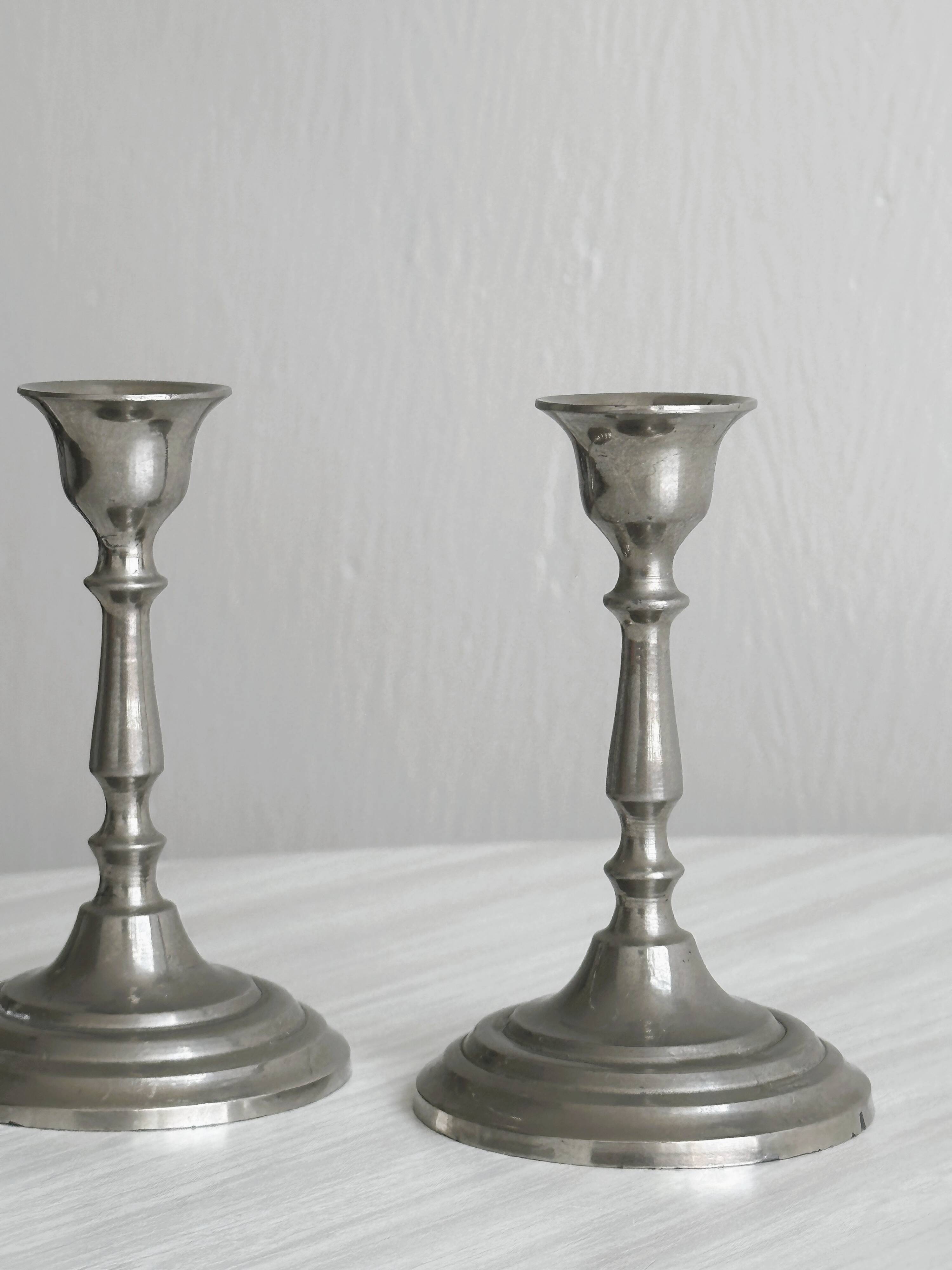 Pair of small metal candle holders, classic design.