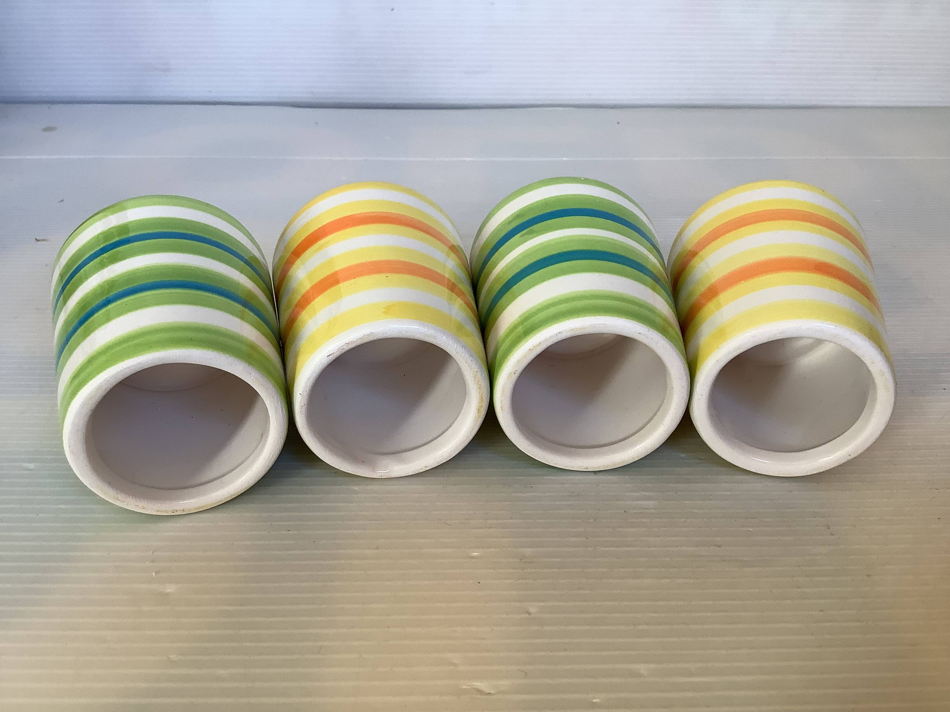 Four striped egg cups in yellow and green.
