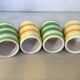Four striped egg cups in yellow and green.
