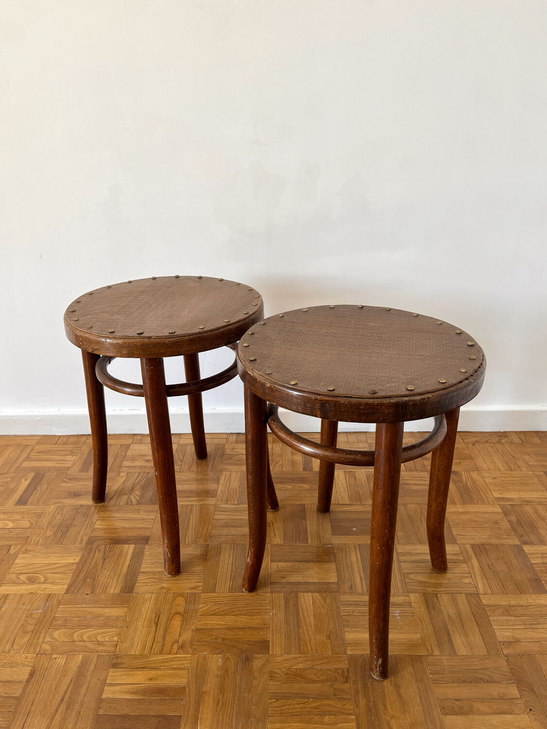 2 antique bistro stools with curved wood and caning effect.