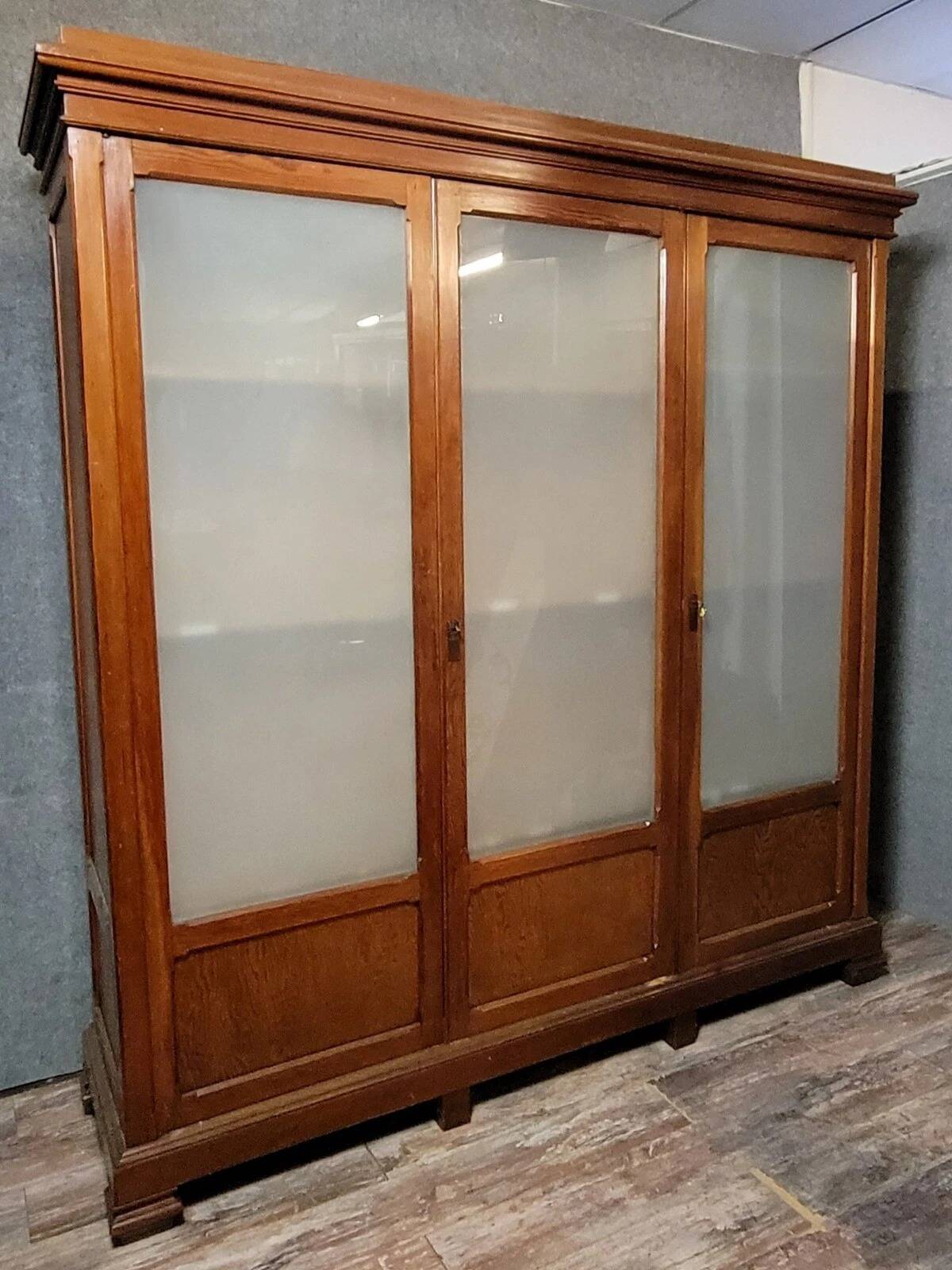 Large pine bookcase with three doors, fitted with frosted glass.