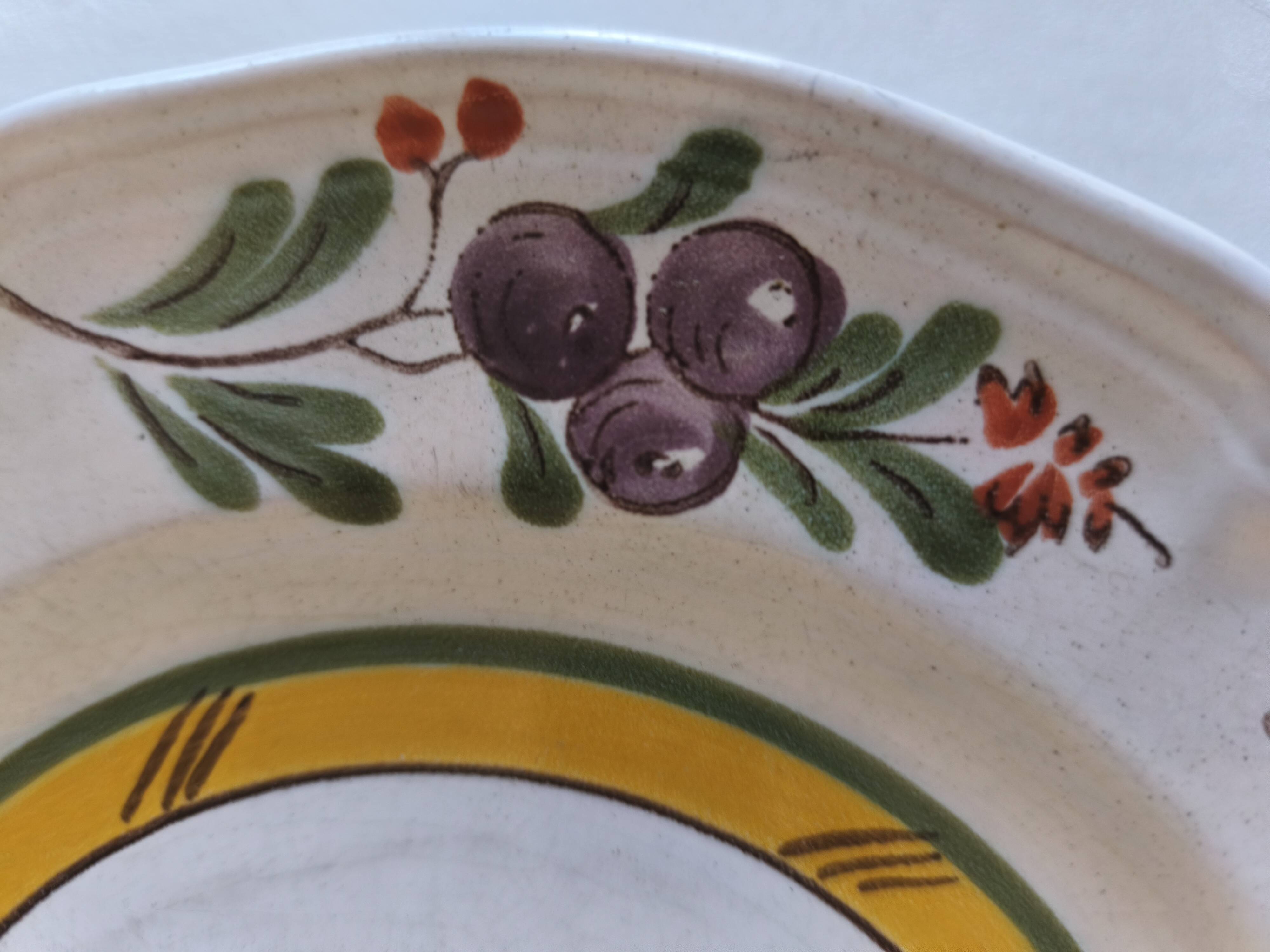 Two earthenware plates with fruits, pears and plums.