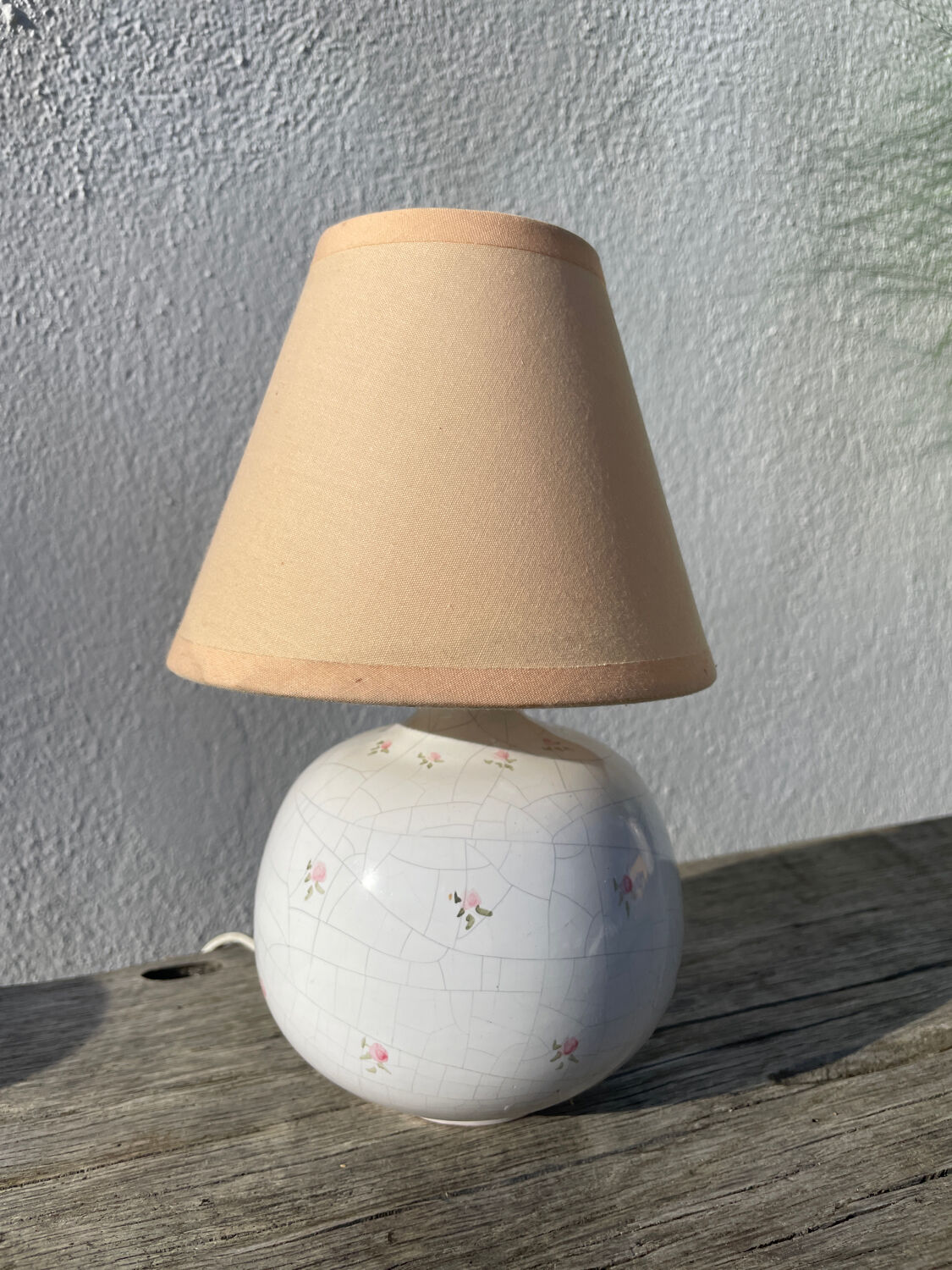 Small cracked white ceramic lamp with flowers.