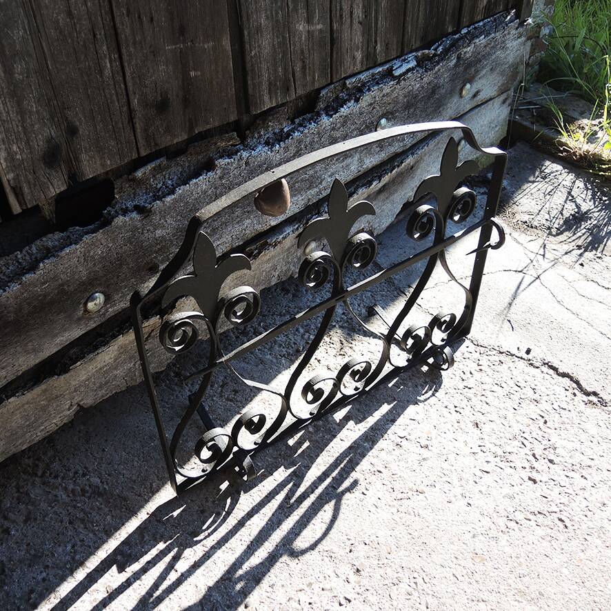 Old wrought iron fleur-de-lis fire screen