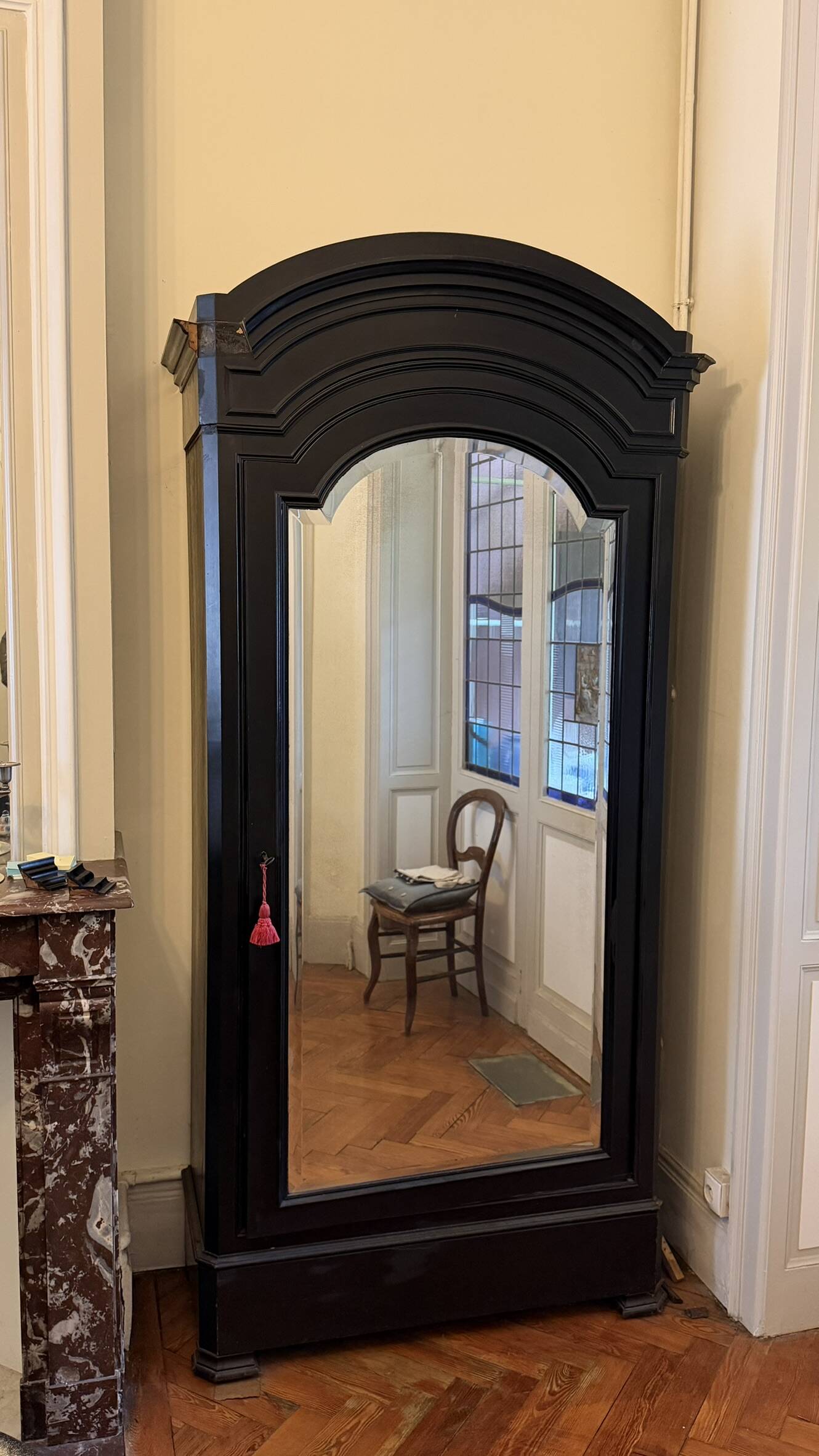 Black wardrobe with a mirrored door in ebony finish.