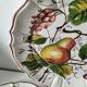 Set of three earthenware plates from Bassano, hand-painted with fruit and flower designs.