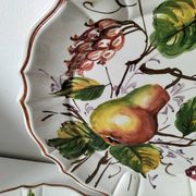 Set of three earthenware plates from Bassano, hand-painted with fruit and flower designs.