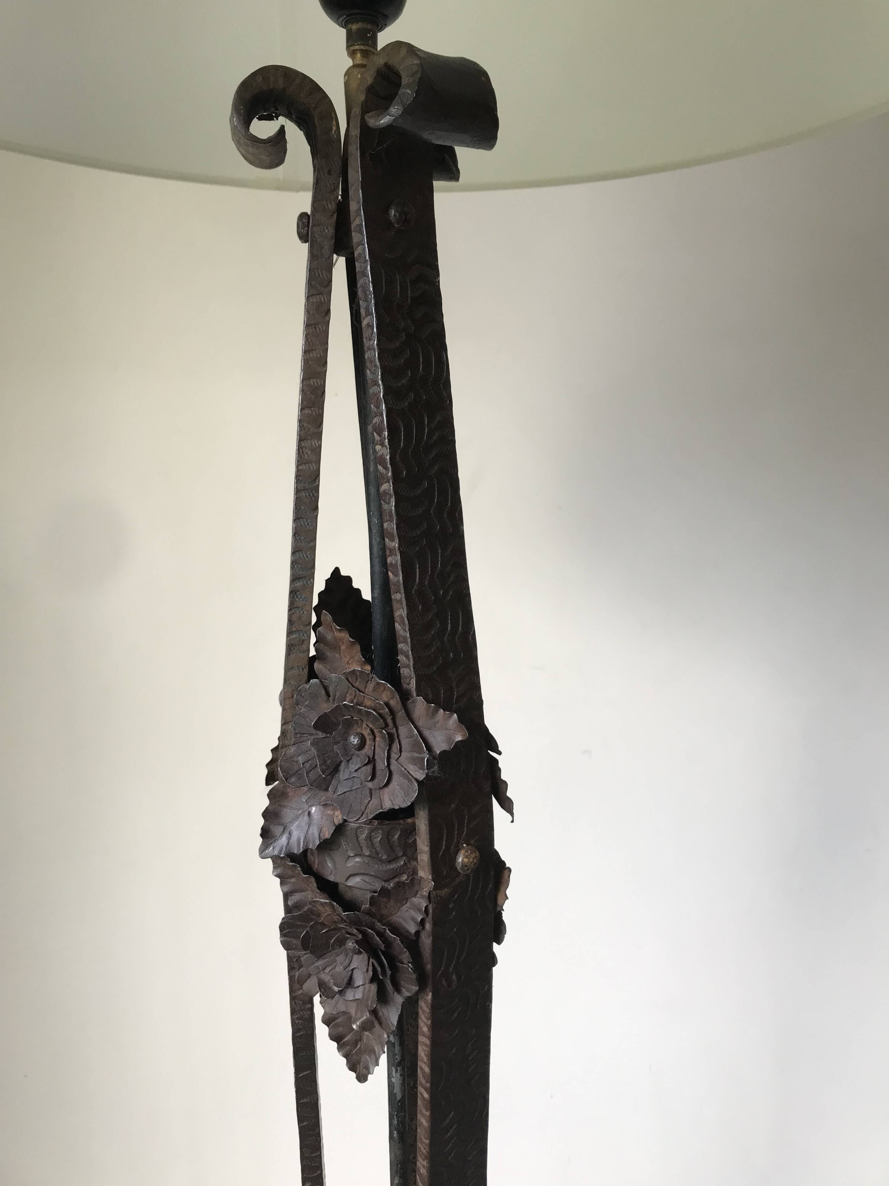 Art deco wrought iron floor lamp decorated with flowers, circa 1930.
