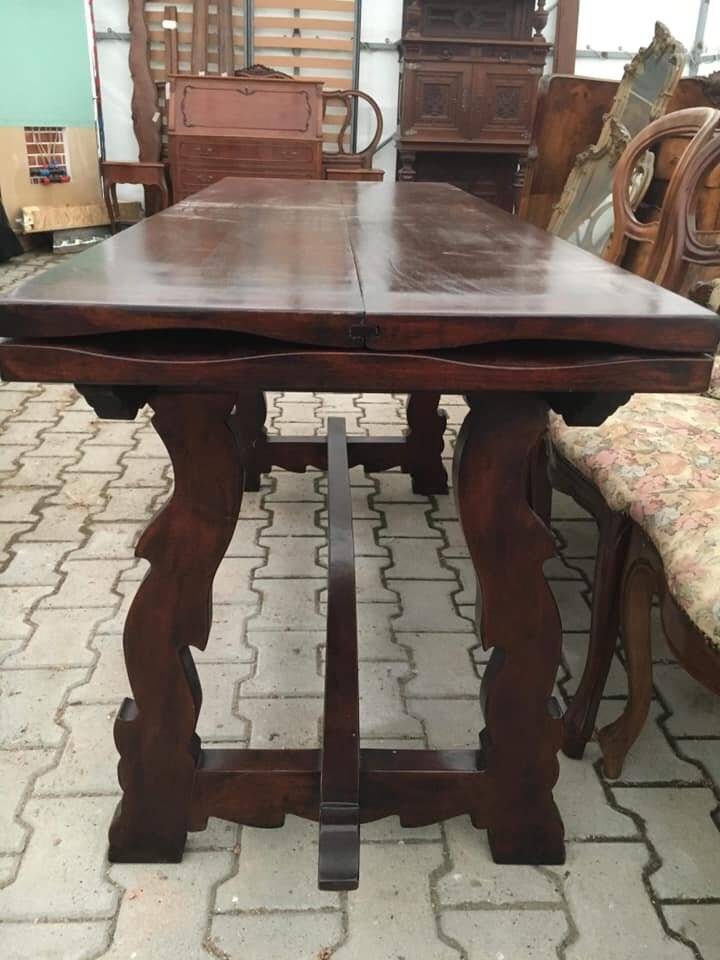 19th-century brown walnut dining table with sculpted trestle legs.