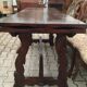 19th-century brown walnut dining table with sculpted trestle legs.