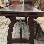 19th-century brown walnut dining table with sculpted trestle legs.