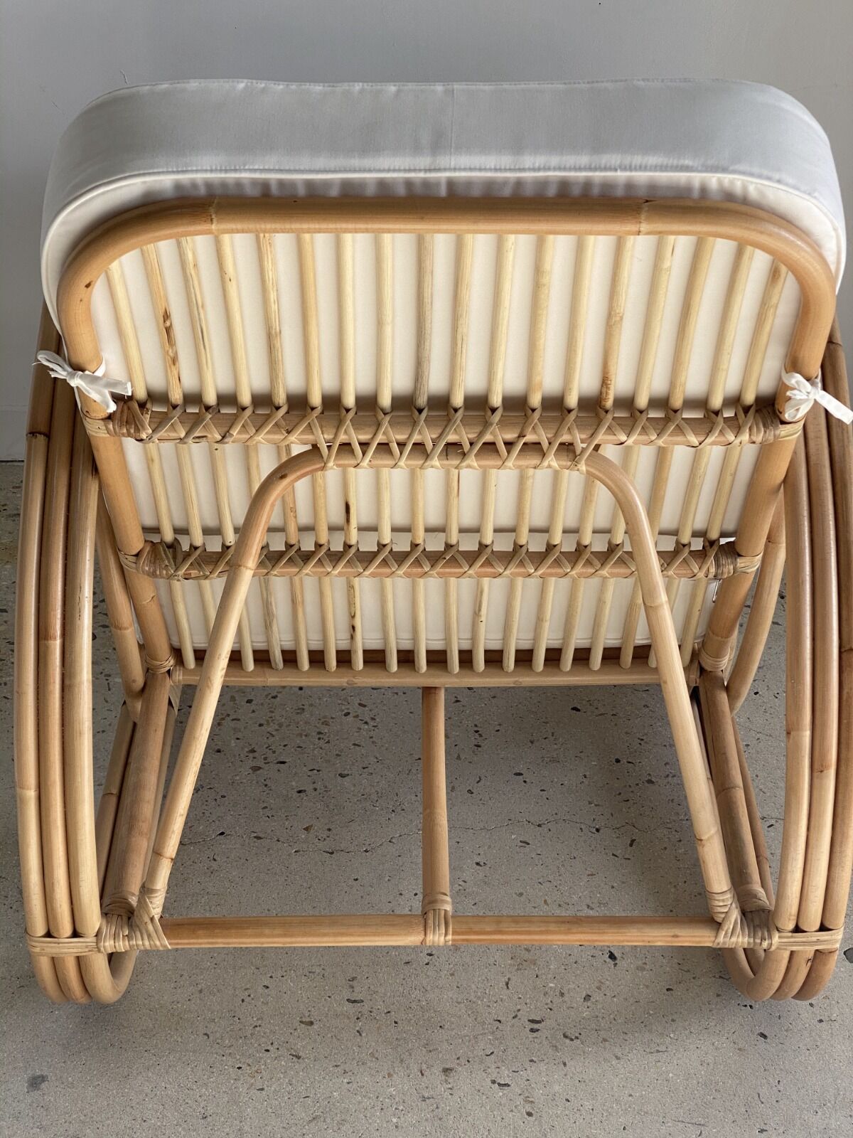 Large rattan rest chair and white cushions