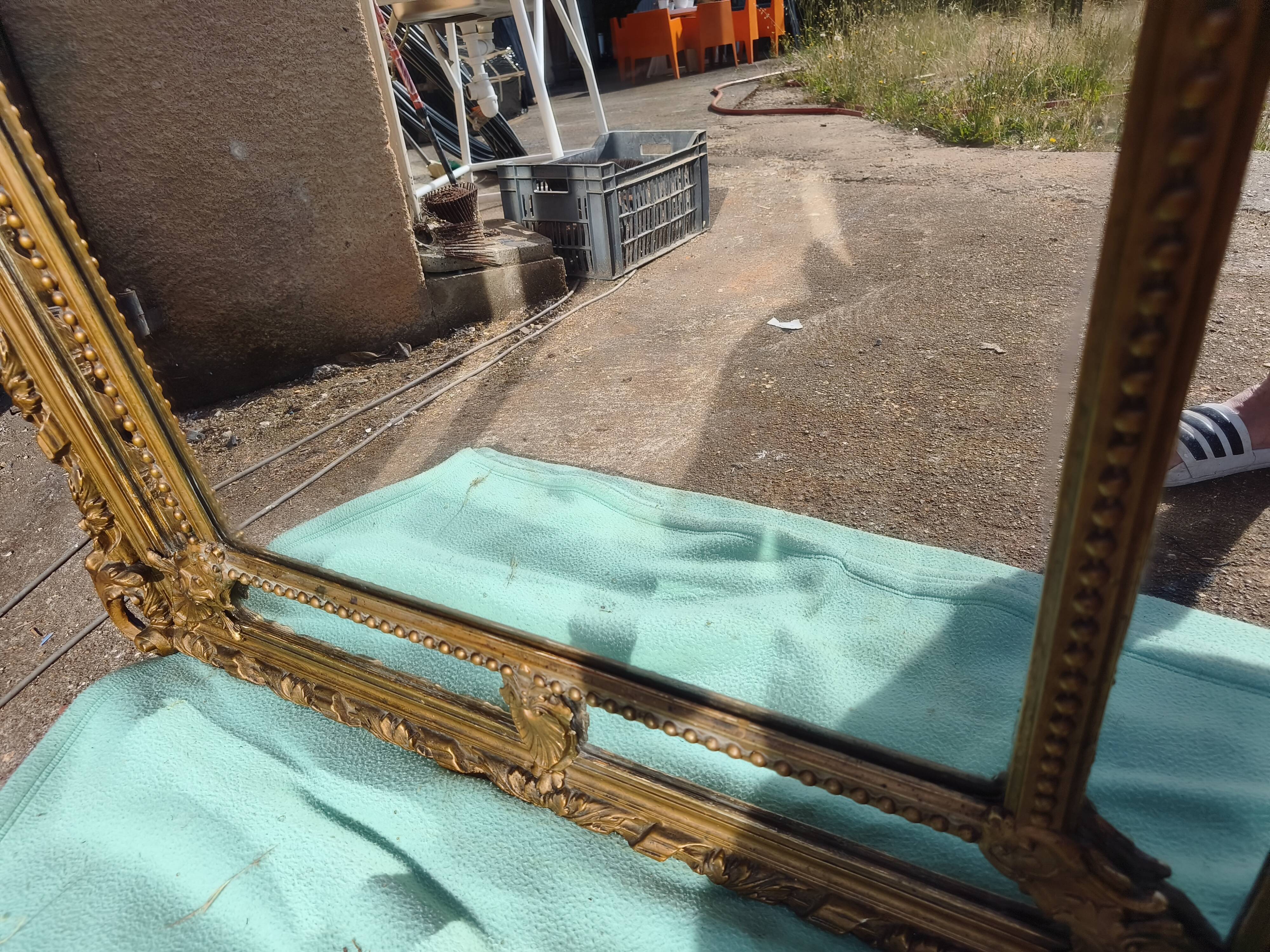 Large closed mirror, 19th century, wood and gilded stucco.