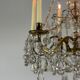 Golden bronze chandelier trimmed with drop-shaped grapevines