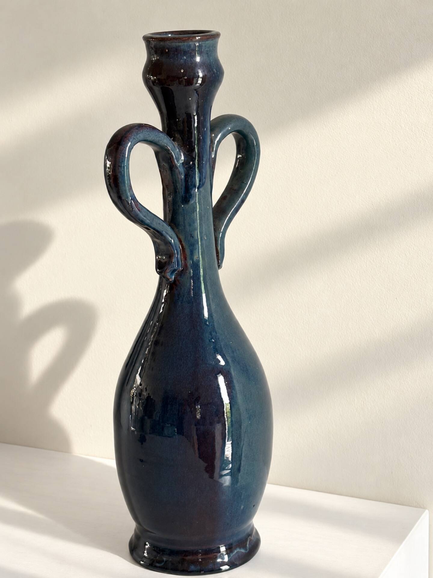 Decorative deep blue glazed ceramic vase with twin handles.