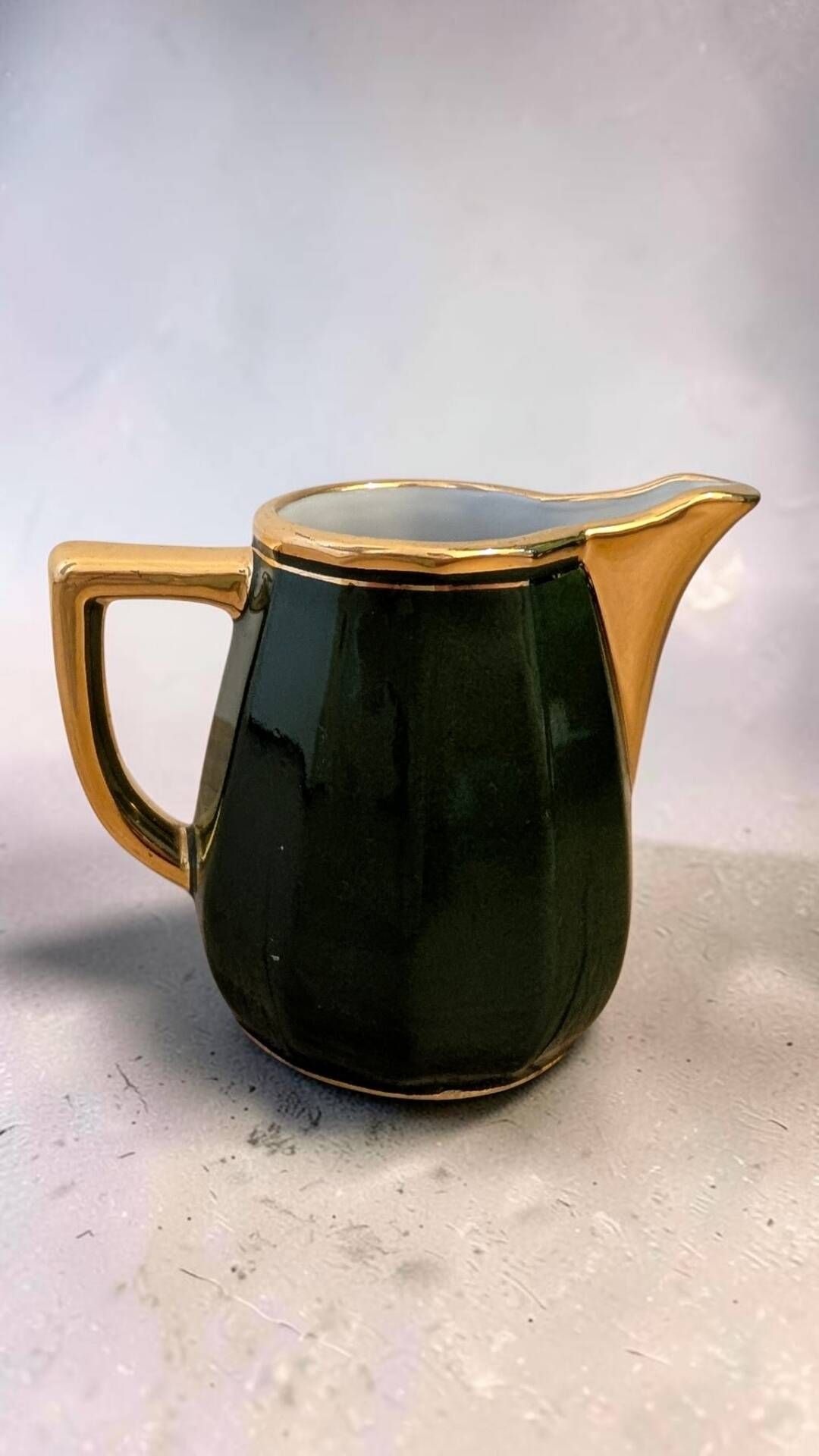 Dark green ceramic decorative jug with golden trim.