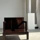 Small low armchair in varnished brown wood