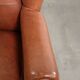 Light cognac-coloured cow leather wingback armchair with matching piping