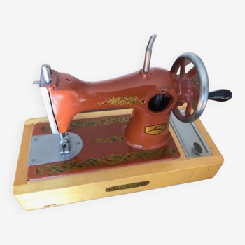 Mini Soviet metal sewing machine on wooden stand
