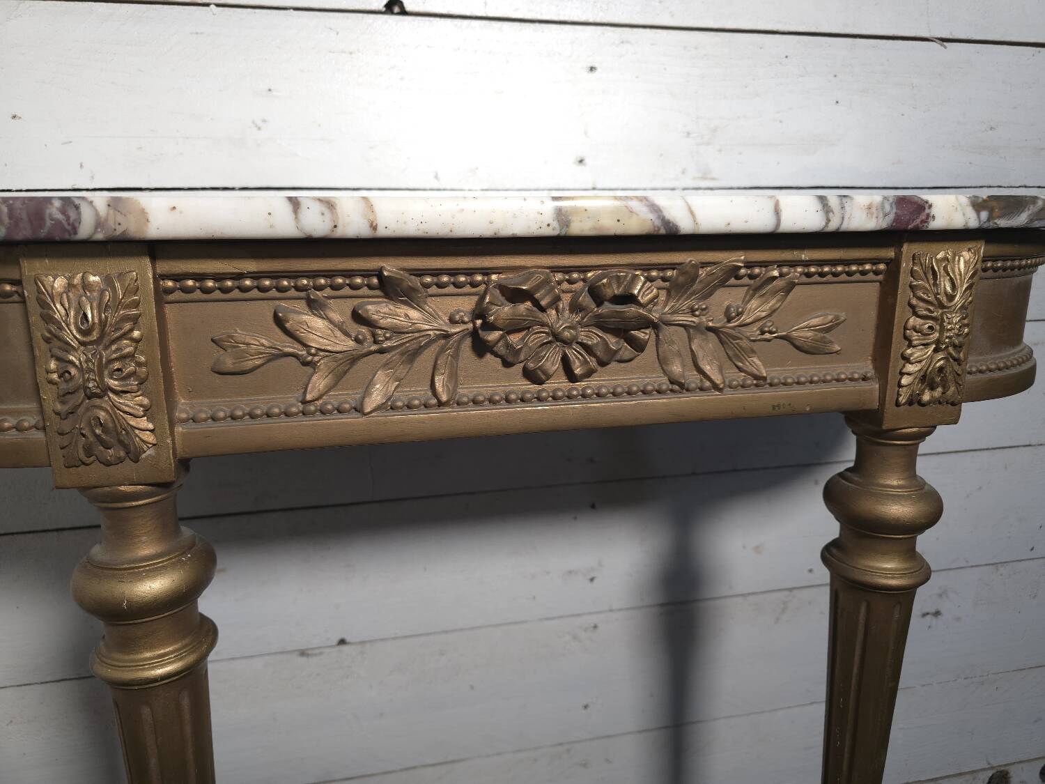 Louis XVI style console in gilded wood with a marble top.
