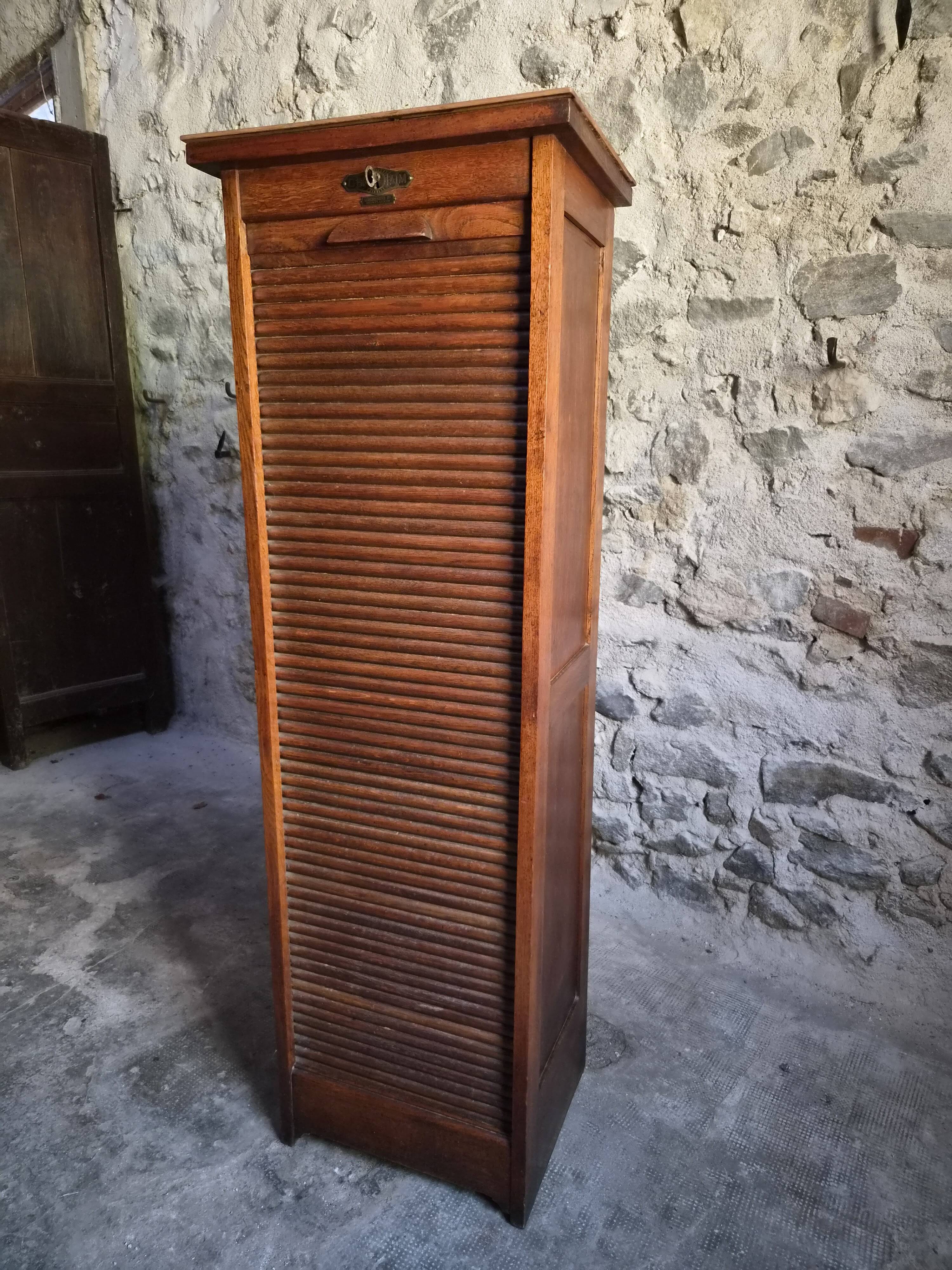 French antique wardrobe with curtain in oak, circa 1920–1930.