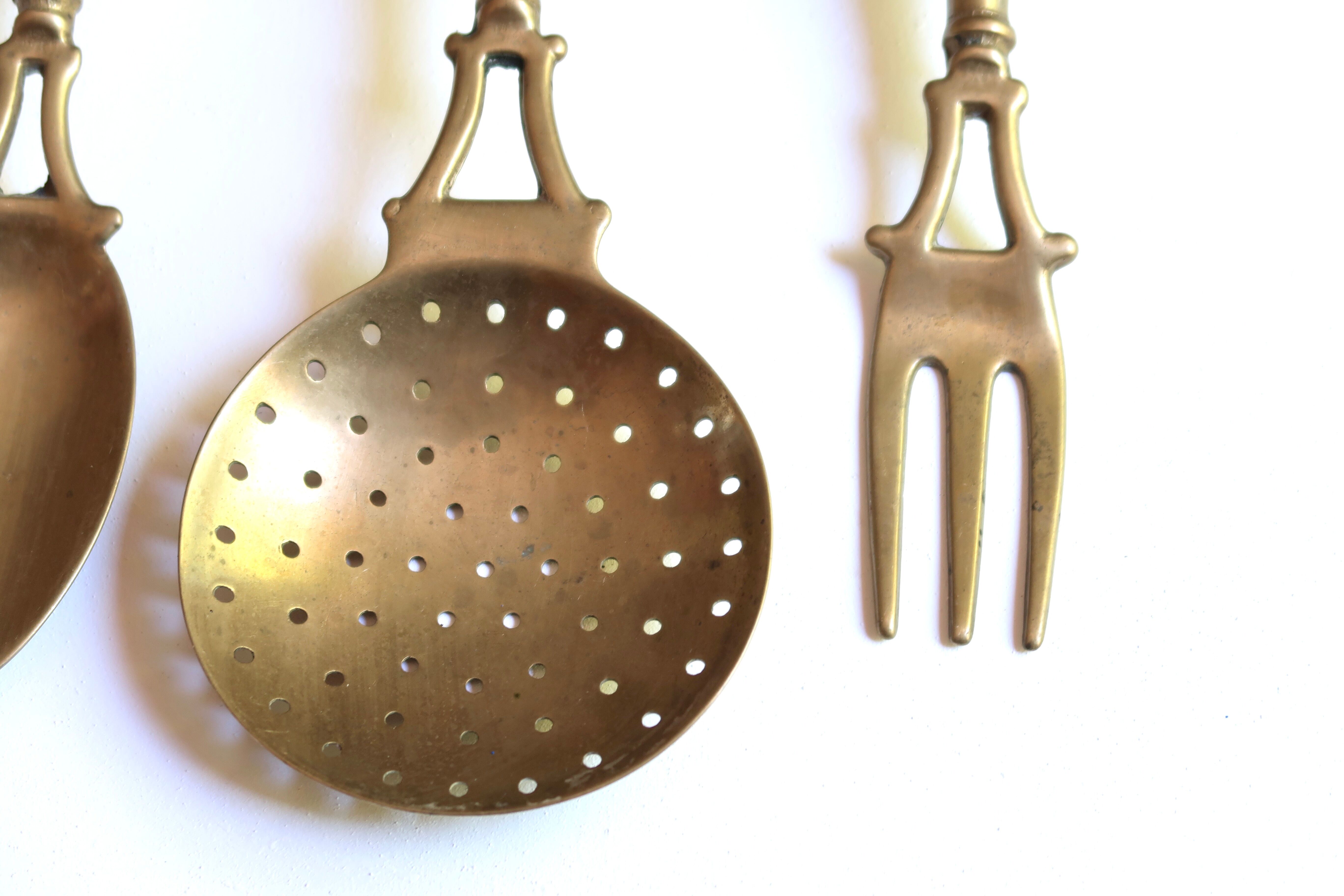 Brass and wood kitchen utensils with wall display, 60s